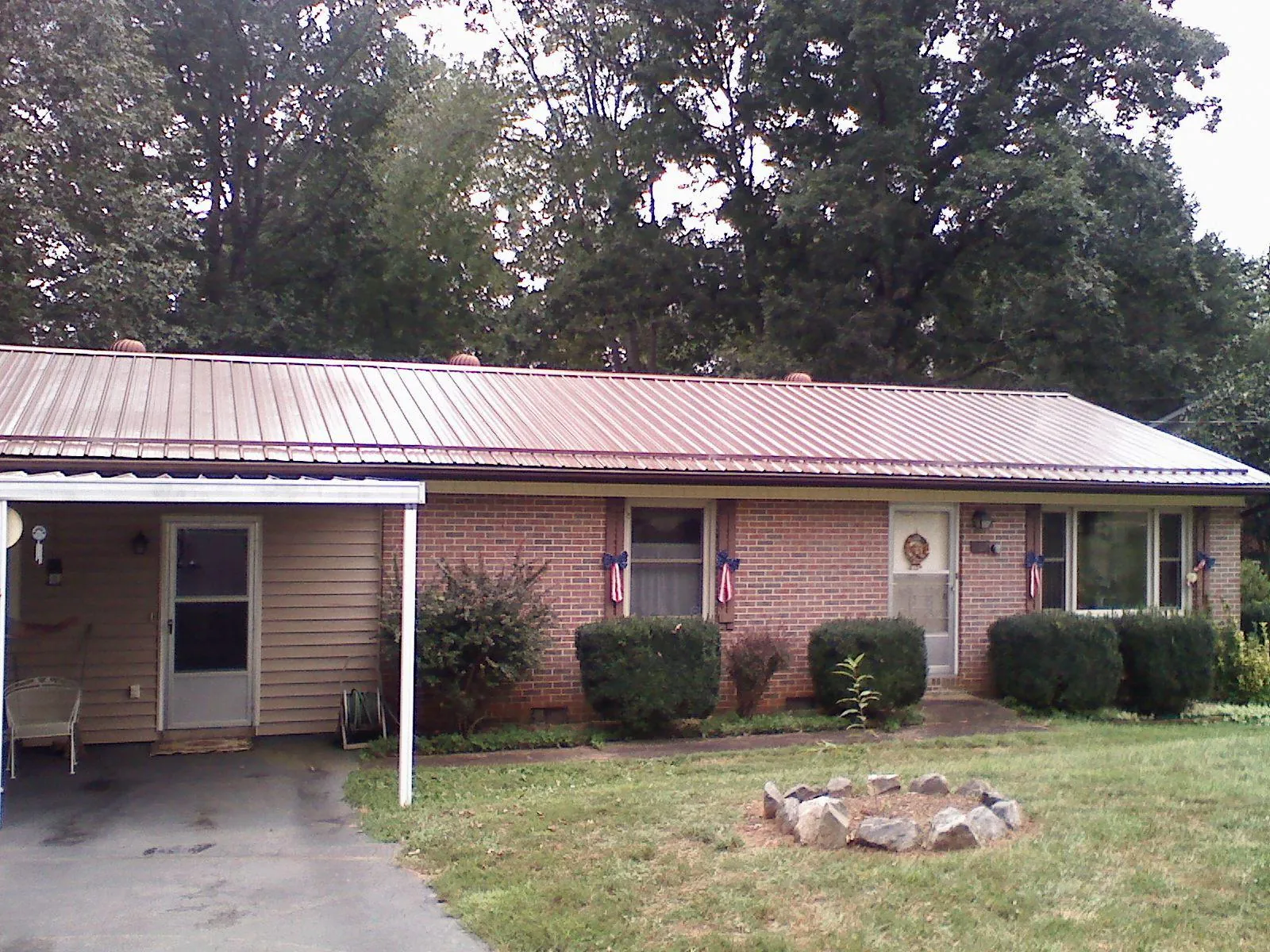 Bronze metal roof and carport on a brick ranch home in Sidney